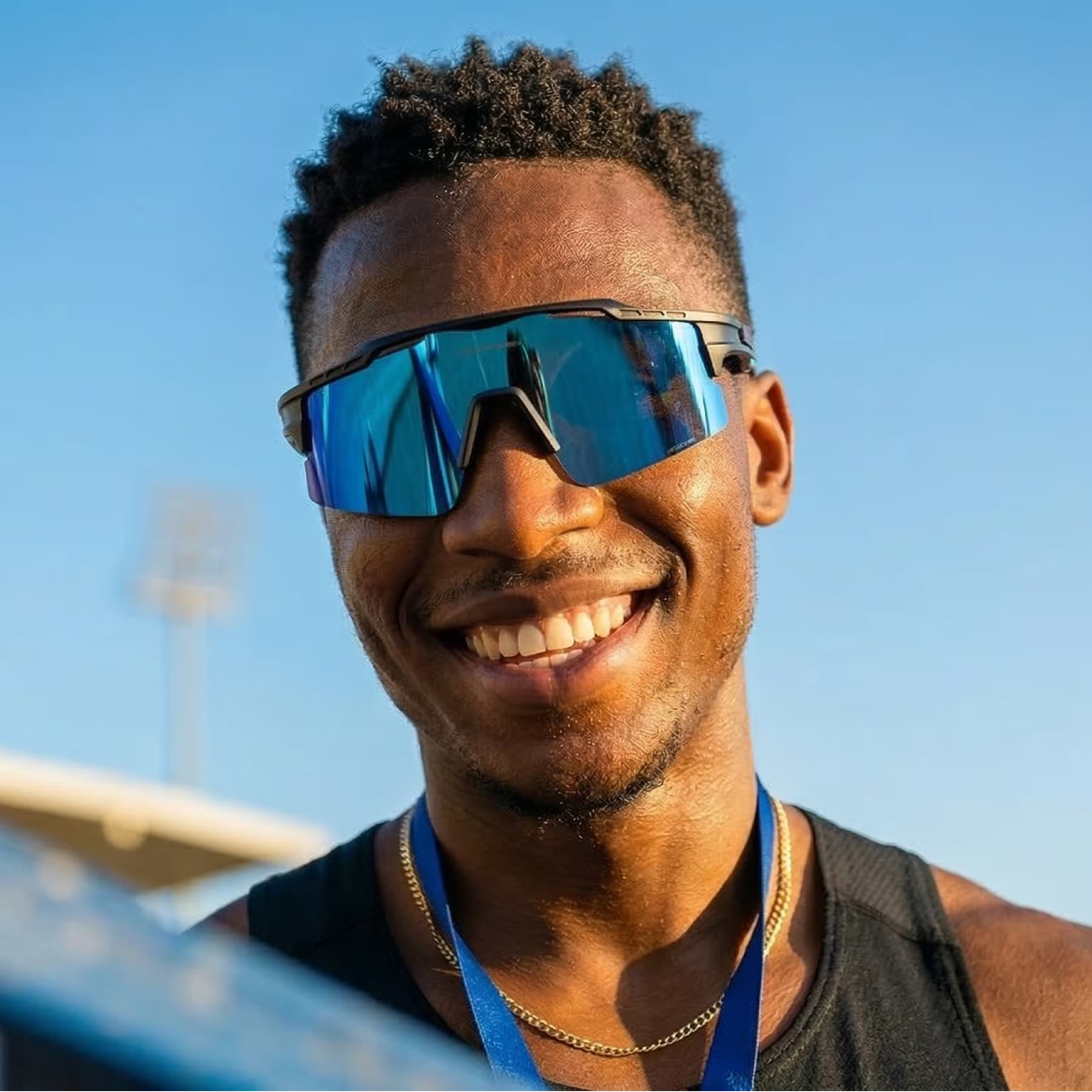 Man wearing reflective sunglasses with a clear blue sky background